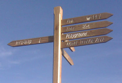 Finger post sign manufactured from reclaimed timber, with infilled lettering.